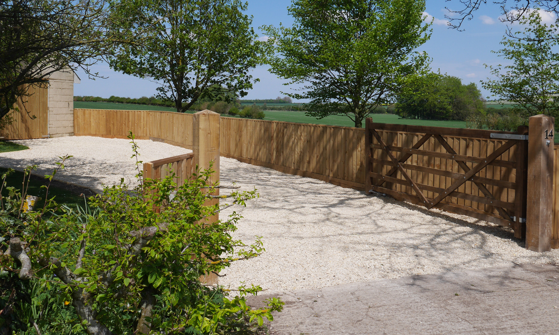 3ft Feather Edge fence, 5-bar gate, local shingle driveway and bespoke shiplap garage doors.